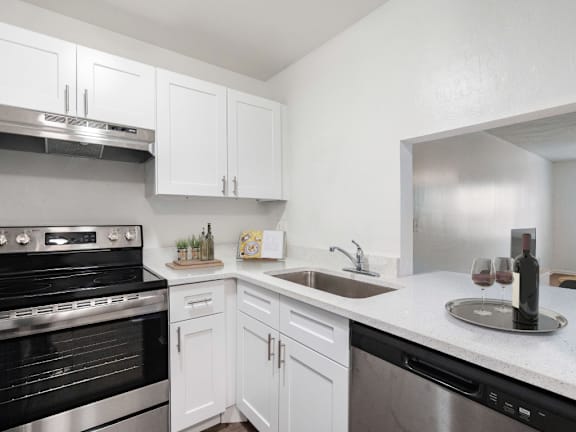 A kitchen with white cabinets and a black oven.