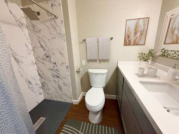 A bathroom with a toilet, sink, and shower.