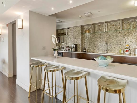 a kitchen with a long counter and three stools