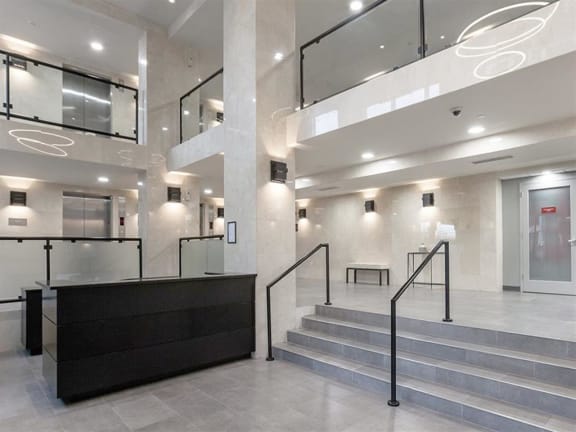 a large lobby with a staircase and a reception desk Prospect Place Apartments in Hackensack, NJ