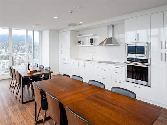 A modern kitchen with a wooden table and chairs.