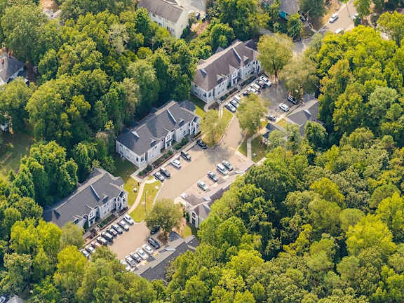 an aerial view of several houses surrounded by trees