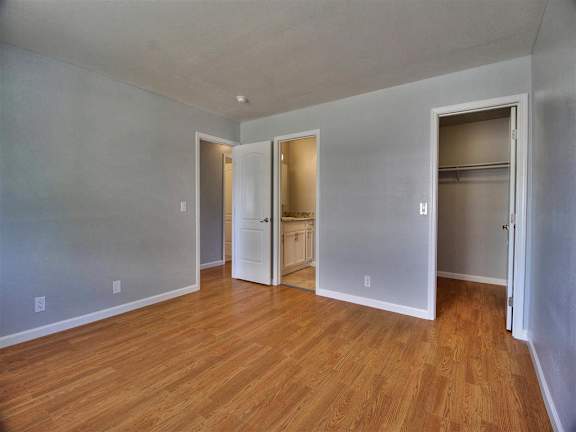 A room with a carpeted floor and a window with blinds.
