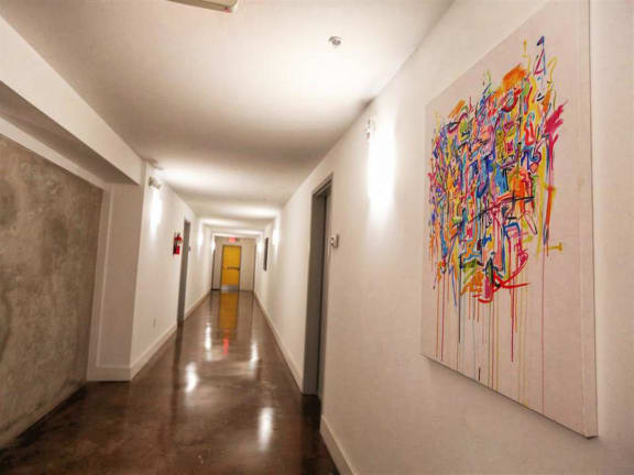 A hallway with a large painting on the wall. at The Mobile Lofts, Alabama, 36604
