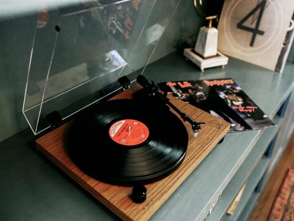 Vinyl record player sitting on top of a wooden cutting board at The James Hollywood in Los Angeles, CA 90028