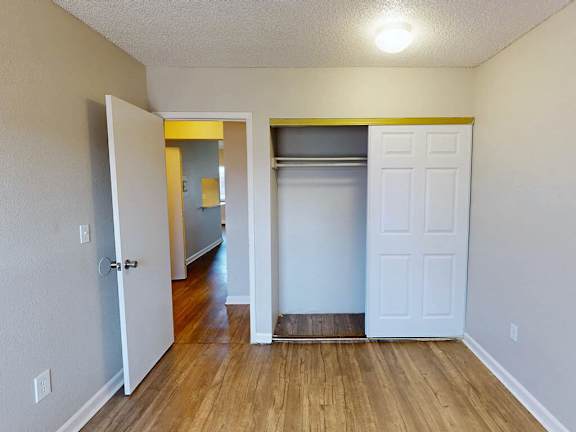 A room with a white door and a white closet.