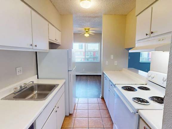 A kitchen with white cabinets and a stove top oven.