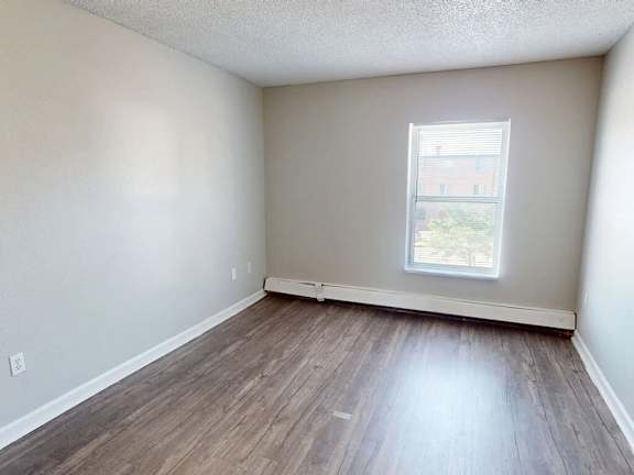 A room with a window and wooden flooring.