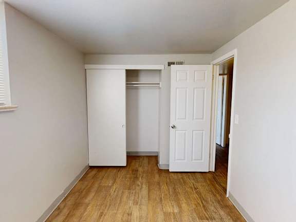 A room with a white door and a white closet.