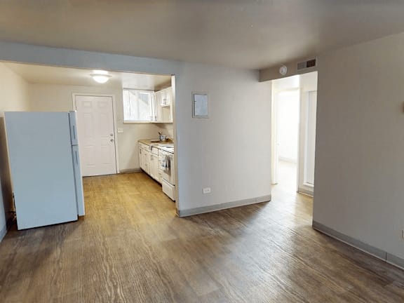 A kitchen area with a refrigerator, sink, and cabinets.