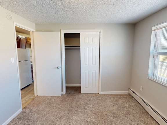 A room with a white door and a carpeted floor.