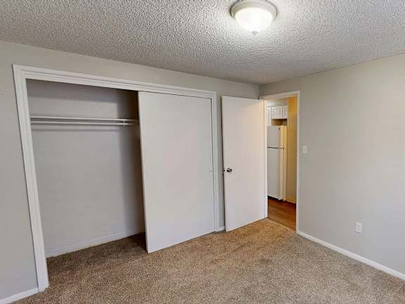 A room with a carpeted floor and a white door.