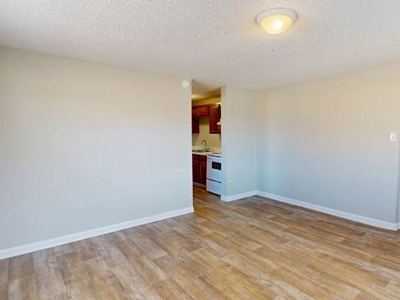 A room with a wooden floor and a white wall.