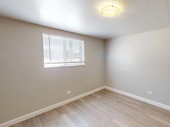 A room with a window and wooden flooring.