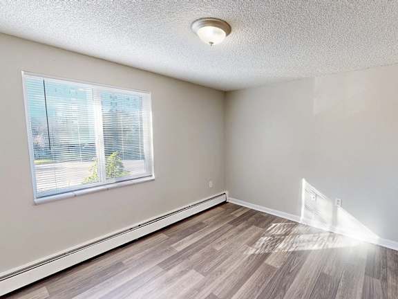 A room with a window and wooden flooring.