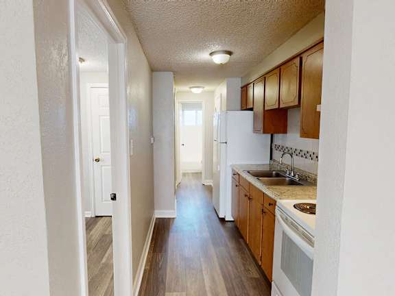 A kitchen with wooden cabinets and a white refrigerator.