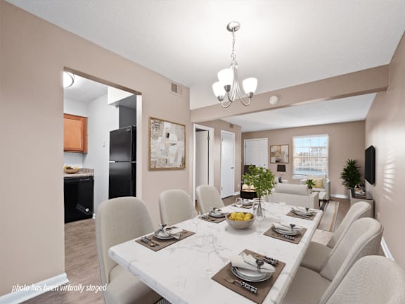 A dining room with a white table and chairs.
