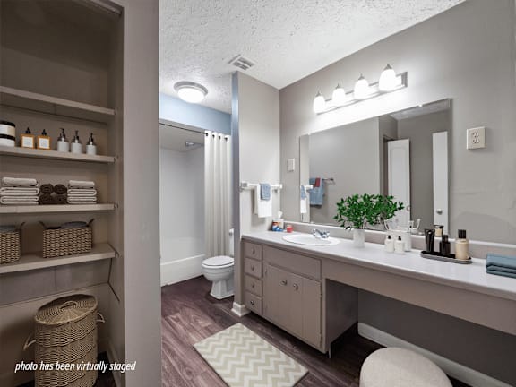 A bathroom with a white toilet, sink, and mirror.