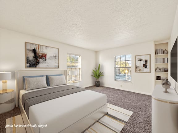 A bedroom with a large bed and a painting on the wall.