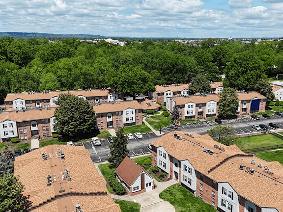 A large apartment complex with a parking lot in front.