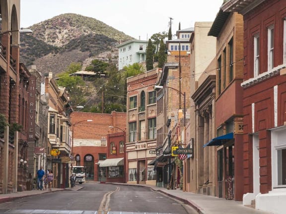 a city street with buildings and a mountain in the background