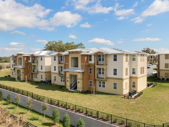 an aerial view of an apartment building with a green lawn