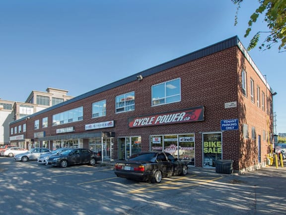A building with a red brick facade has a sign that says "CYCLE POWER" on it.