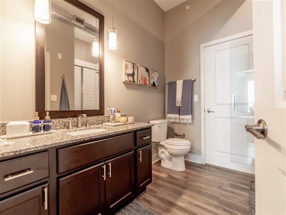 A bathroom with a toilet, sink, and mirror at The Foundry Apartments , South Bend, IN, 46617