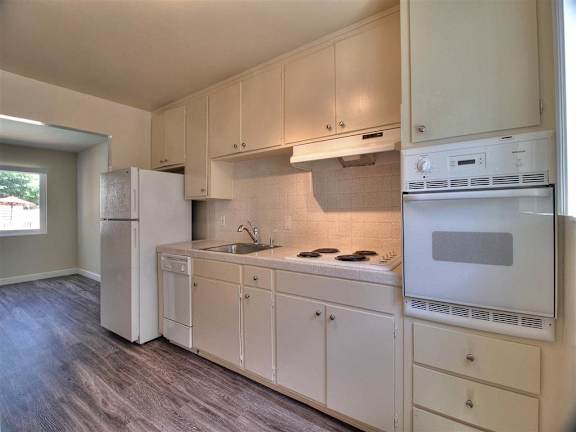 A kitchen with white appliances and cabinets.