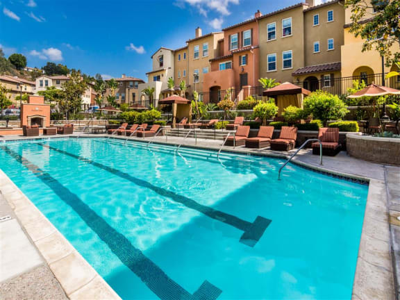 Apartments in Oceanside California - Piazza D'Oro Resort Style Swimming Pool With Lounge Chairs, Fire Pit, and Cabanas
