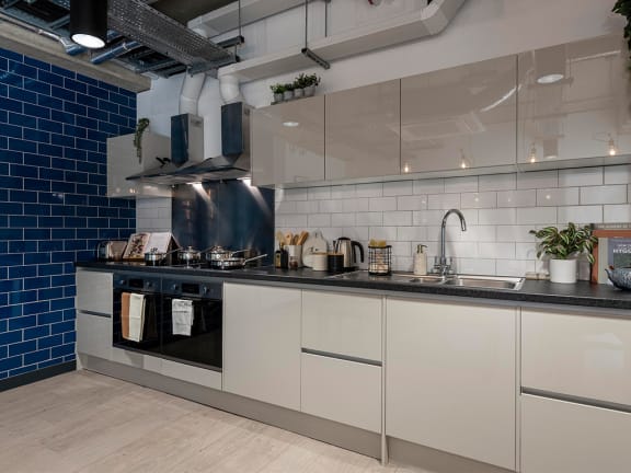 a kitchen with white cabinets and a black counter top