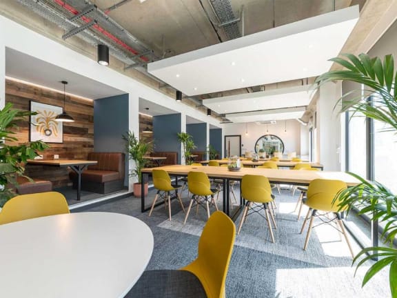 a large conference room with yellow chairs and tables