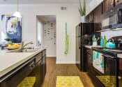 Thumbnail 5 of 27 - Shaker-style mocha cabinetry with brushed nickel hardware at CLEAR Property Management , The Lookout at Comanche Hill, Texas, 78247