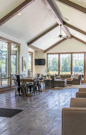 An indoor lounge area with tables and chairs and high ceilings at Riverplace Apartment Homes, Independence