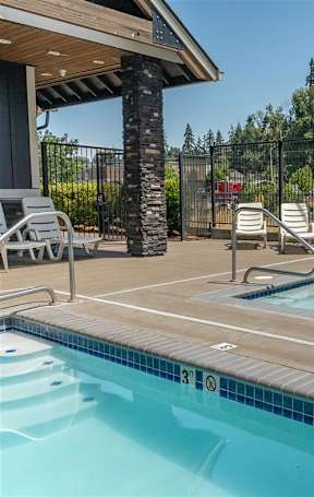 A swimming pool in a residential area with a blue chair.