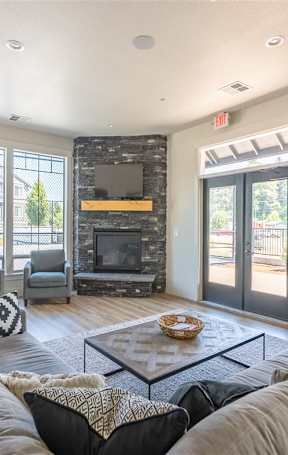 A modern living room with a fireplace and a large window overlooking a pool.