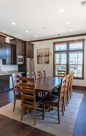 A modern living room with a fireplace and a large window overlooking a pool at Stoneplace Apartment Homes, Molalla, OR, 97038