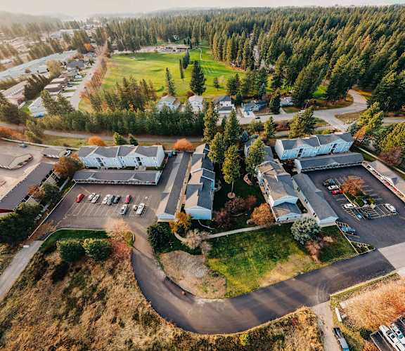 a birds eye view of a parking lot with houses and trees
