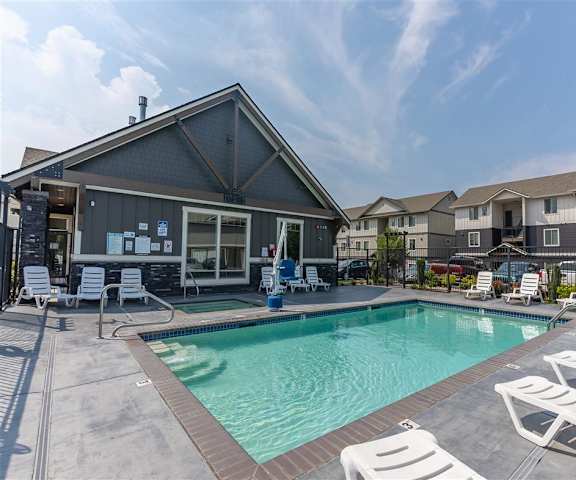 A pool area with apartments in the background at Sandyplace Apartment Homes, Sandy, OR, 97055