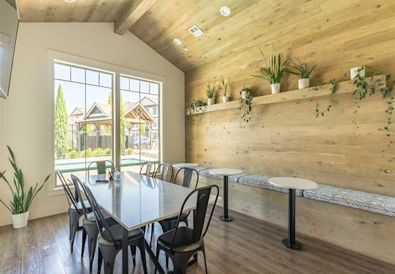 A room with tables and chairs and a large window with natural light at Timberridge Place Apartment Homes, Albany, 97322