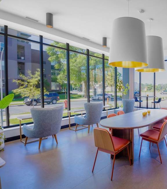 A room with a table and chairs with a view of the outside.