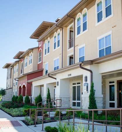 A row of apartment buildings with balconies and doors.