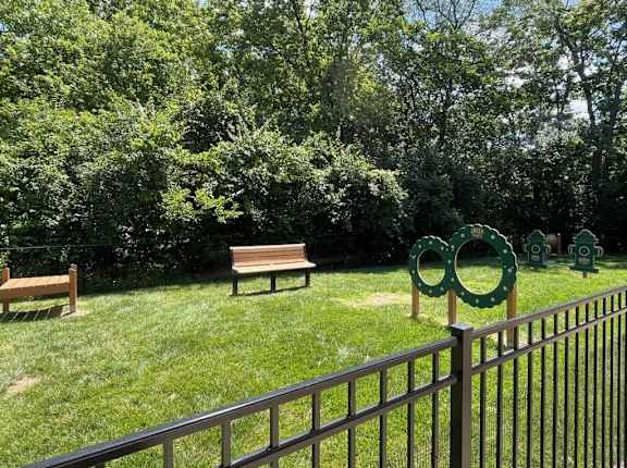 a park with two benches and a fence