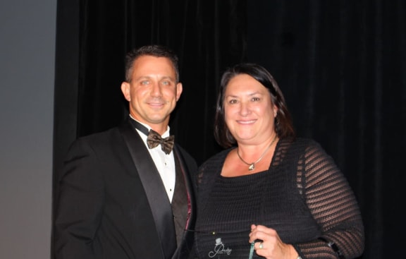 person receives award from person for her contribution to the community