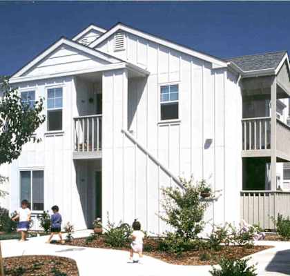 a white home with children playing in front of it