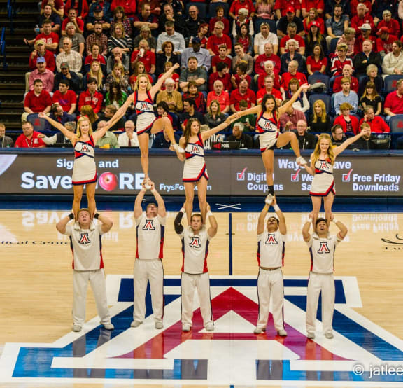 the cheerleaders perform for the crowd at a basketball game