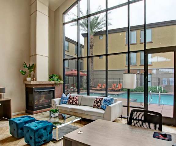 a living room with a large window and a pool in the background