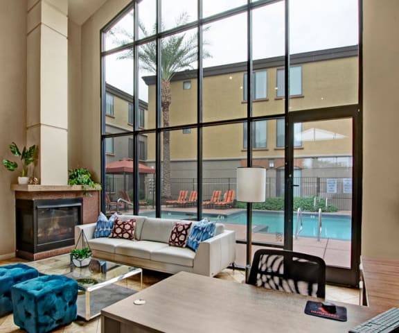a living room with a large window and a pool in the background