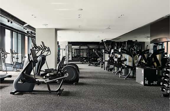 A gym with a variety of equipment including treadmills, weights, and exercise machines.