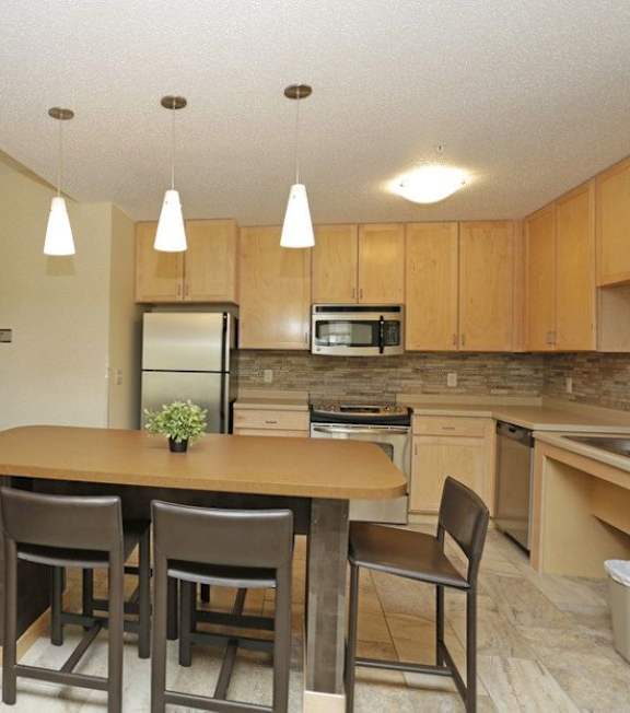 A kitchen with two tables and chairs.